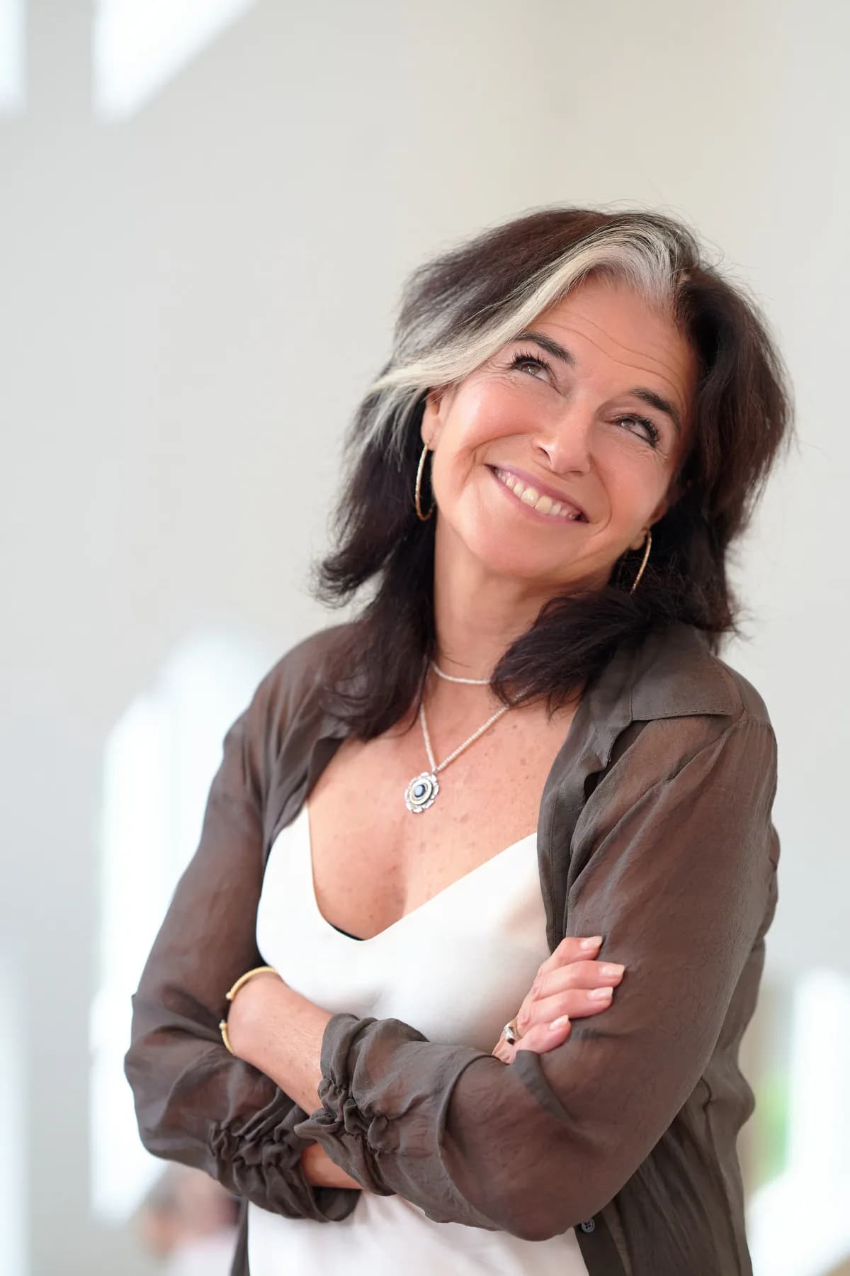 Nathalie Niddam looking up confidently with arms crossed