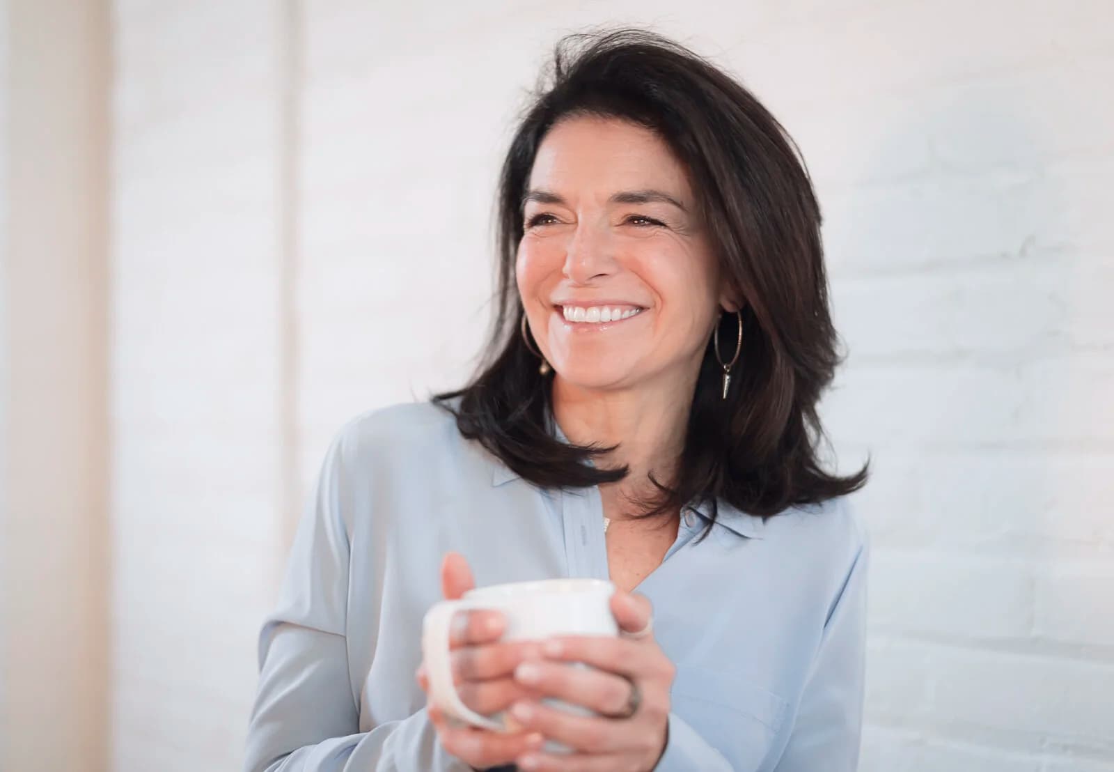 Nathalie Niddam smiling warmly with a coffee